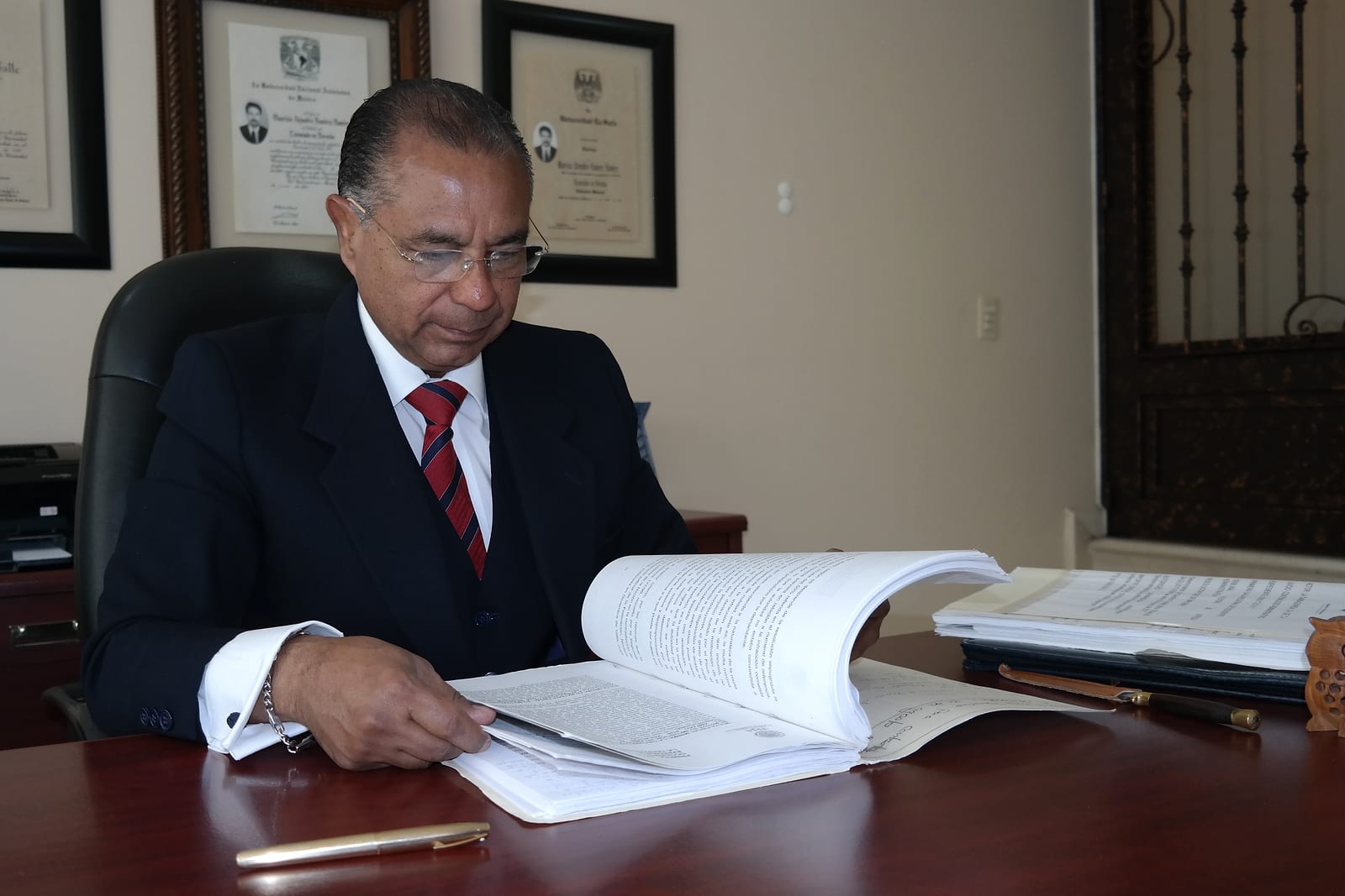 Lic. Mauricio A. Ramírez R. revisando un expediente en su despacho